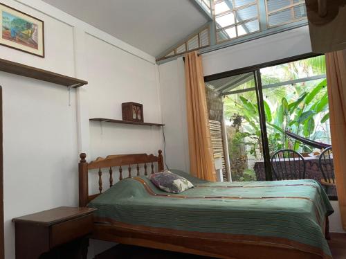 a bedroom with a bed and a large window at Casita Coco in Puerto Limón