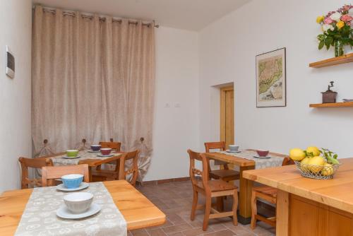 菲納萊利古雷的住宿－Al Riparo Affittacamere，用餐室配有木桌和椅子