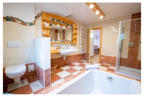 uma casa de banho com uma banheira, um WC e um lavatório. em Chalet Bergbauernhof em Afritz am See