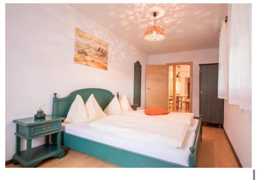 um quarto com uma cama com uma cabeceira verde e uma mesa em Chalet Bergbauernhof em Afritz am See