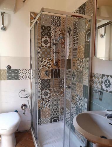 a bathroom with a shower and a toilet and a sink at Giovi Guesthouse in Acquasparta