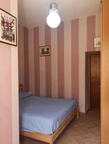 a bedroom with a bed and a striped wall at Giovi Guesthouse in Acquasparta