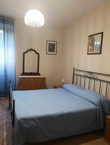 a bedroom with a blue bed and a mirror at Giovi Guesthouse in Acquasparta