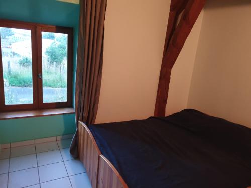 1 dormitorio con cama y ventana en Chambre d'hôtes Aubrac Nasbinals a75 