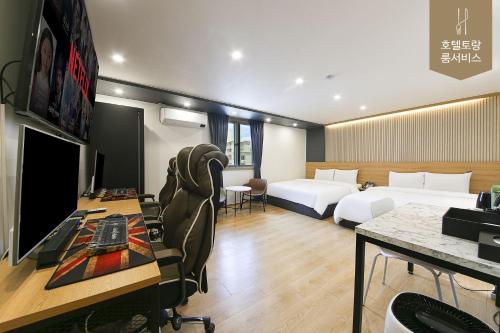 Habitación de hotel con 2 camas y escritorio en Hotel Torang Jeonju en Jeonju