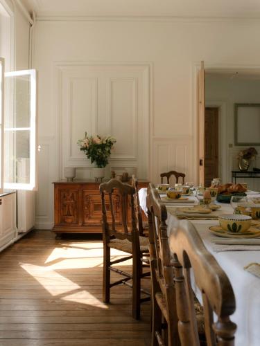 Un comedor con mesa y sillas y una cocina. en Petit Chateau Vercourt, en Vercourt