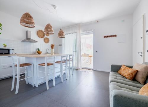 een keuken en een woonkamer met een tafel en een bank bij Casa al Mare 10 in Fano