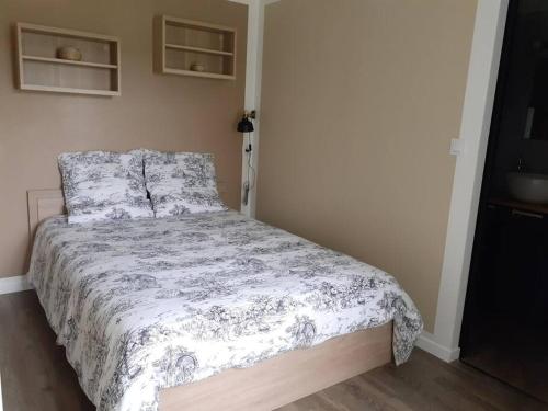 een slaapkamer met een bed met een dekbed erop bij La Grelauderie 4 in Saintes