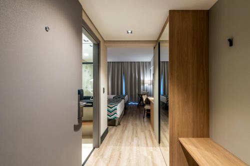 a corridor of a hotel room with a bedroom at Japy Golf Resort Hotel in Cabreúva