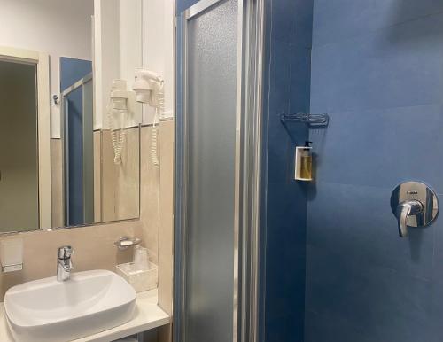ein Bad mit einem Waschbecken und einer Dusche mit einem Spiegel in der Unterkunft Hotel Sayonara in San Benedetto del Tronto