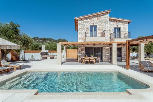 a villa with a swimming pool and a house at Bedrock beachside villa with private pool in Vasilikos