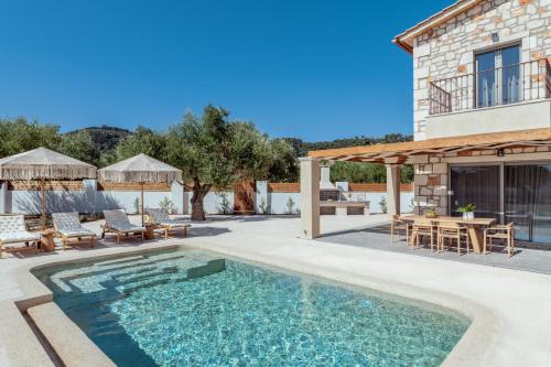 a villa with a swimming pool and a patio at Bedrock beachside villa with private pool in Vasilikos