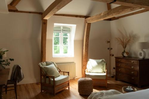 a bedroom with two chairs and a dresser and a window at Petit Chateau Vercourt in Vercourt