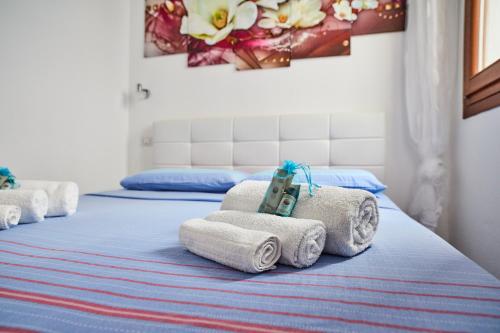 a room with three beds with towels on them at House Matteo La Punzesa in Santa Teresa Gallura