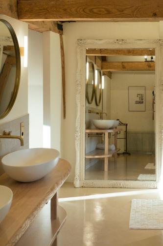une salle de bain avec deux lavabos et un miroir dans l'établissement Petit Chateau Vercourt, à Vercourt
