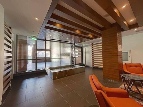 a large lobby with a tub and orange chairs at Downtown Toronto Condo Suite in Toronto
