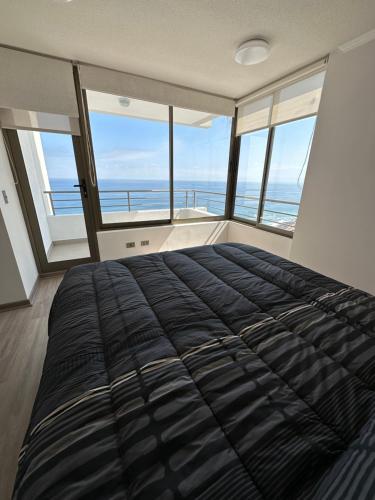 um quarto com uma cama e vista para o oceano em Departamento 3D2B Condominio Altos de Huayquique em Iquique