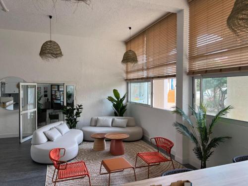 un salon avec un canapé blanc et des chaises rouges dans l'établissement Résidence Goélia Le Grand Bleu, au Barcarès