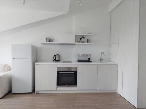 a white kitchen with a stove and a refrigerator at Mini Condos® 28DL - 1 bed condo, 2 min to the sea in Tivat
