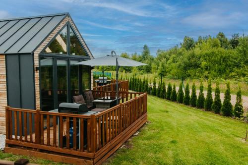 a house with a deck with an umbrella at LUXURY CAMP - 150 m od Suntago Park in Grabce-Towarzystwo