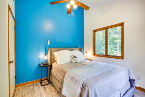 a blue bedroom with a bed and a ceiling fan at Lakefront New York Abode with Deck, Grill and Fire Pit in Mahopac