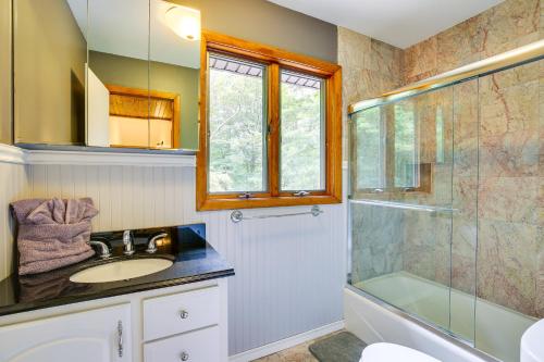 uma casa de banho com um lavatório e uma cabina de duche em vidro. em Lakefront New York Abode with Deck, Grill and Fire Pit em Mahopac