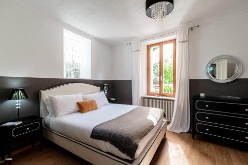 1 dormitorio con cama, espejo y ventana en Casa Celeste by Quokka 360 - flat with a view of Lake Lugano, en Caslano