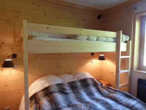 - une chambre avec 2 lits superposés dans un mur en bois dans l'établissement Bel appartement 2 pièces à Méribel, terrasse, proche pistes, 5 pers, WiFi - FR-1-411-613, à Les Allues