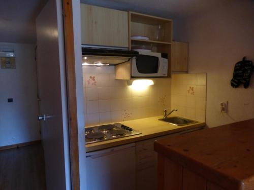 une petite cuisine avec un évier et un micro-ondes dans l'établissement Appartement au cœur de Méribel, 4 pers., balcon sud, proche pistes et commerces - FR-1-411-693, à Les Allues