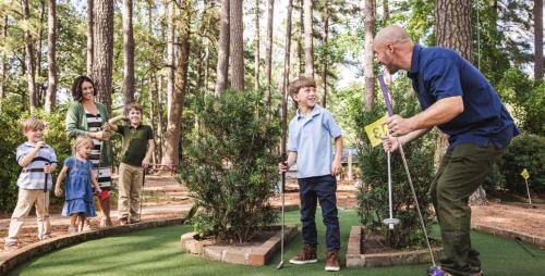 an older man playing golf with a group of children at Williamsburg Woodlands Hotel & Suites, an official Colonial Williamsburg Hotel in Williamsburg