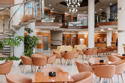 a cafeteria with tables and chairs and stairs at Hotel Las Gaviotas in La Manga del Mar Menor