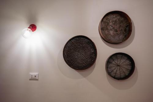 a wall with three bowls and a light on a wall at N'incanto in Rutigliano