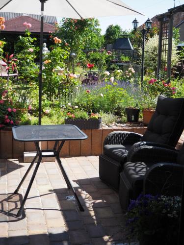 eine Terrasse mit einem Tisch und Sofas im Garten in der Unterkunft foxxbau - urlaubswohnen im Saarschleifenland in Merzig