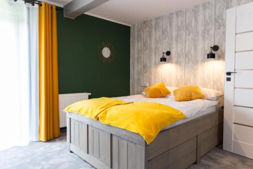 una camera da letto con un grande letto con cuscini gialli di Leśna Przystań a Muszyna