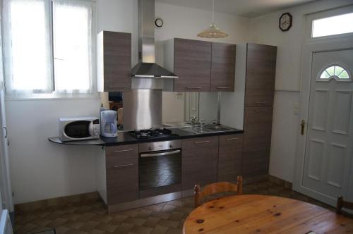 une cuisine avec une cuisinière et une table à l'intérieur dans l'établissement Maison en Touraine, à Bléré