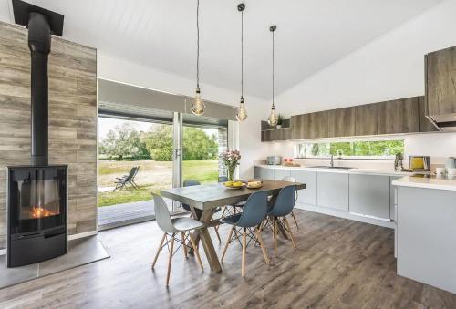 a kitchen with a dining table and a fireplace at Stunning 3 Bed Lodge, Log Burner & Hot Tub with Lake View - Lakeside Lodge in Sturminster Marshall