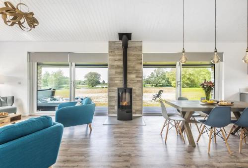 sala de estar con chimenea, mesa y sillas en Stunning 3 Bed Lodge, Log Burner & Hot Tub with Lake View - Lakeside Lodge, en Sturminster Marshall