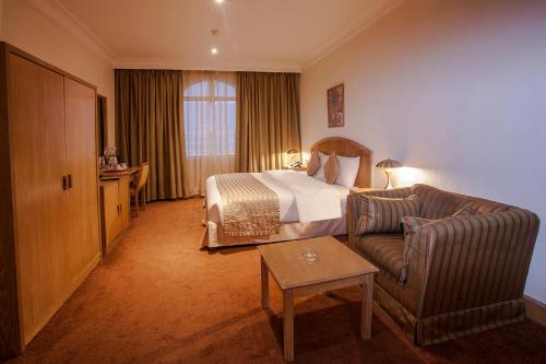 a hotel room with a bed and a couch at HAFFA HOUSE HOTEL in Muscat