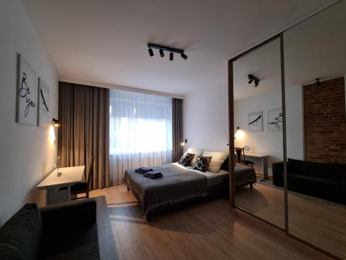 a bedroom with a bed and a large mirror at Apartament 51 in Gdynia