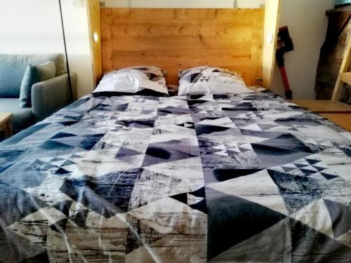 a quilt on a bed in a bedroom at Studio Pour 4 Personnes in Chamrousse