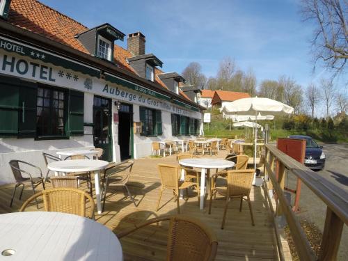 an outdoor patio with tables and chairs and a hotel at Auberge du Gros Tilleul in Argoules