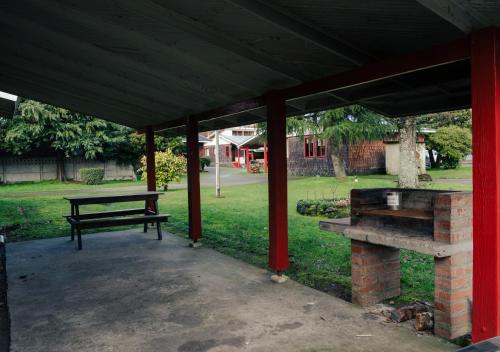 einen Picknicktisch und eine Bank unter einem Pavillon in der Unterkunft Hotel Terrazas del Lago in Puerto Varas