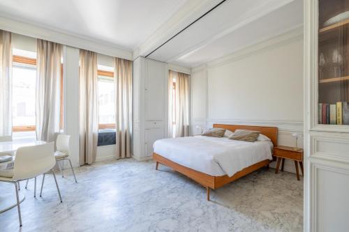 a bedroom with a bed and a desk and some windows at White Suite in Rome in Rome