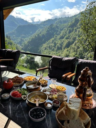 une table remplie de nourriture avec vue sur la montagne dans l'établissement Maysa Suit Bungalov, à Çamlıhemşin