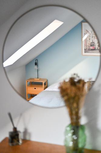 un miroir reflétant une chambre avec un lit et une commode dans l'établissement LA DAME - ETRETAT, à Étretat