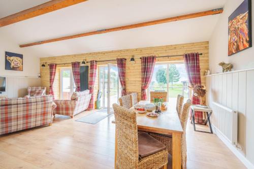 a kitchen and dining room with a table and chairs at The Cow Shed in Sherborne