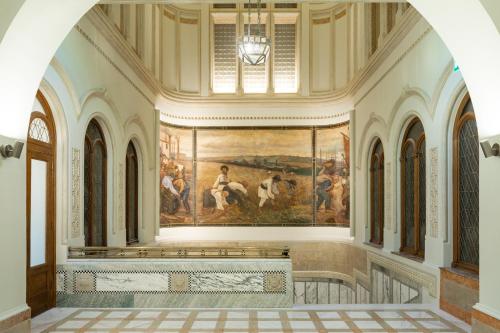 a hallway with a painting on the wall in a building at The Marmorosch Bucharest, Autograph Collection in Bucharest