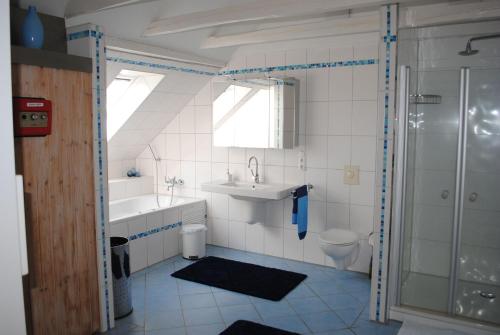 a bathroom with a sink and a tub and a toilet at Ferienwohnung Heckmann, 95138 in Rhauderfehn