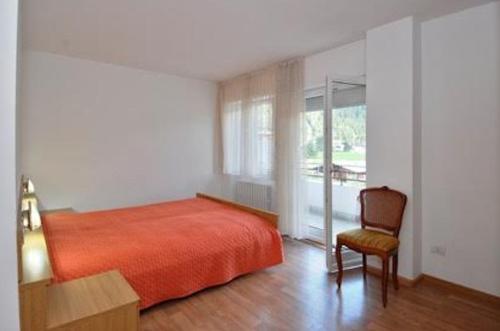 プレダッツォにあるBig Apartmentのベッドルーム1室(ベッド1台、椅子、窓付)