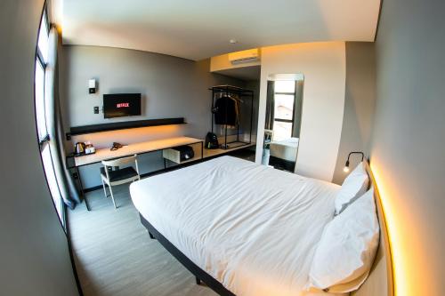 若因維利的住宿－Naalt Hotel Joinville，一间卧室配有一张床和一张带电脑的书桌
